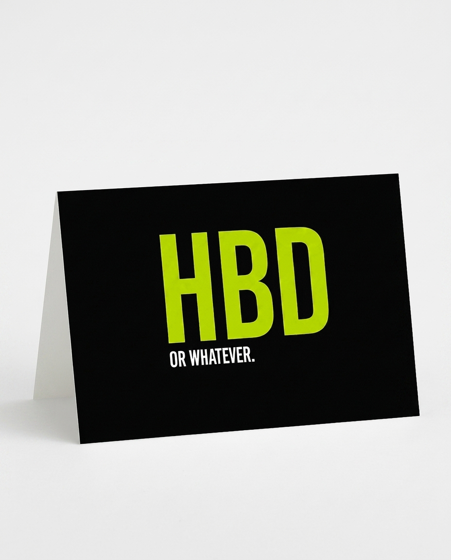 A black A5-sized greeting card with a fold-down stand, featuring the text 'HBD OR WHATEVER.' in bright lime green and white, set against a clean white background.