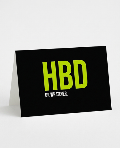 A black A5-sized greeting card with a fold-down stand, featuring the text 'HBD OR WHATEVER.' in bright lime green and white, set against a clean white background.
