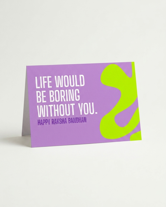 A purple greeting card with a fold-over backing, featuring the text 'LIFE WOULD BE BORING WITHOUT YOU. HAPPY RAKSHA BANDHAN' in white, alongside a bright lime green abstract shape on the right side, photographed on a light gray background.