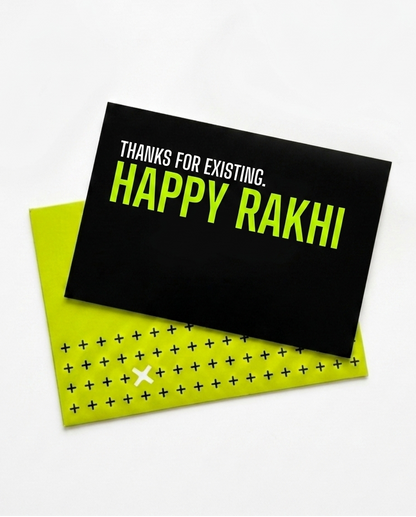 A black greeting card with the text 'THANKS FOR EXISTING. HAPPY RAKHI' in white and bright yellow-green, layered over a lime green envelope